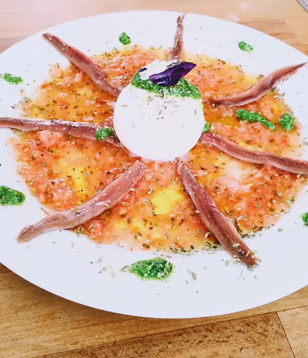 Carpaccio con anchoas y burrata en el centro