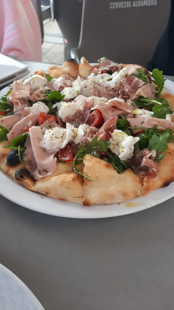 Pizza con jamón, rúcula y queso